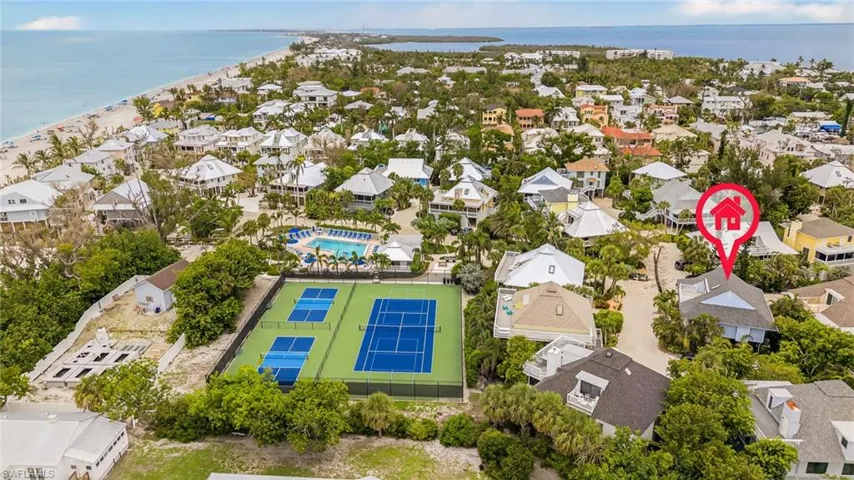 Aerial perspective of suburban area featuring a large body of water and a pool area