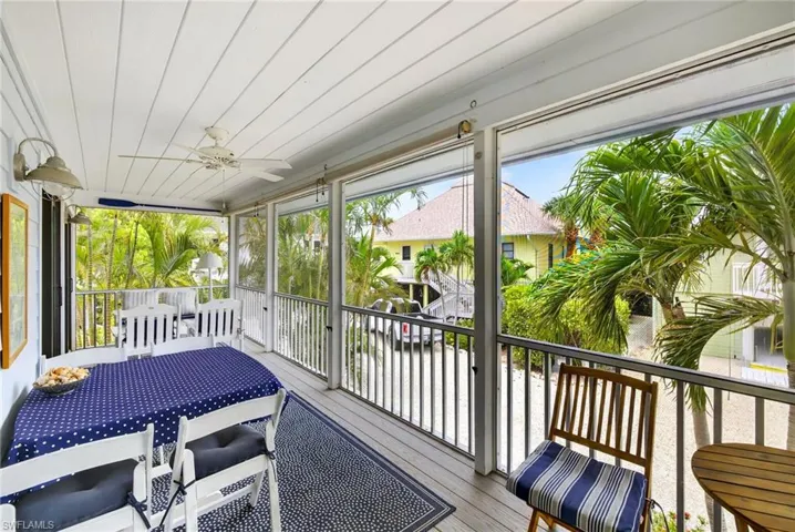 Sunroom / solarium with outdoor dining area and ceiling fan