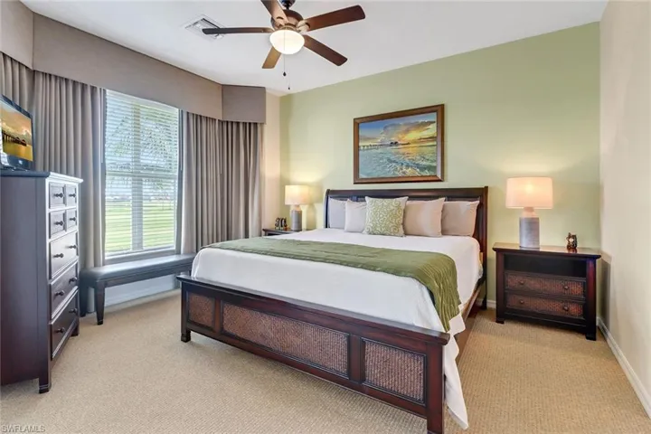 Bedroom with ceiling fan and light carpet