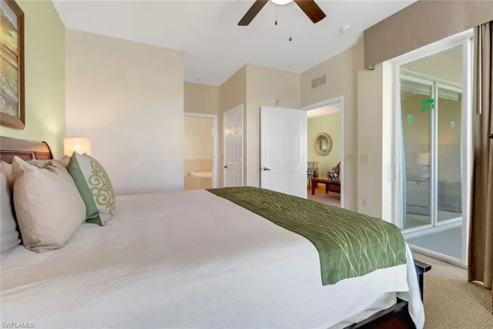 Carpeted bedroom with ceiling fan and ensuite bathroom