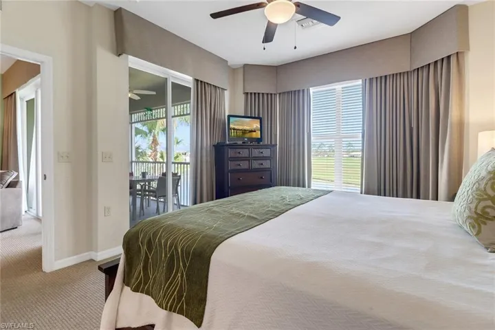 Bedroom featuring ceiling fan, access to exterior, carpet floors, and multiple windows