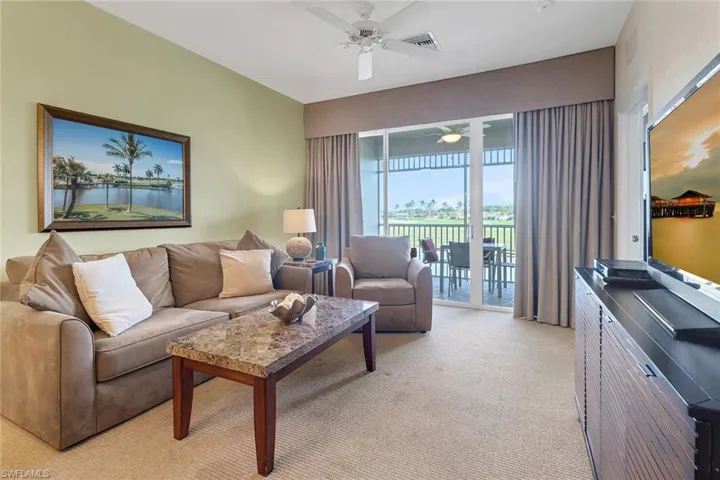 Carpeted living room with ceiling fan