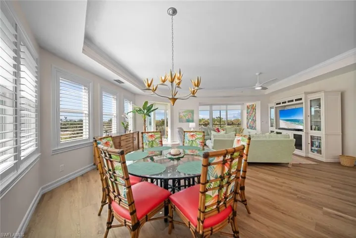Dining area featuring a wealth of natural light, crown molding, light hardwood / wood-style floors, and ceiling fan with notable chandelier