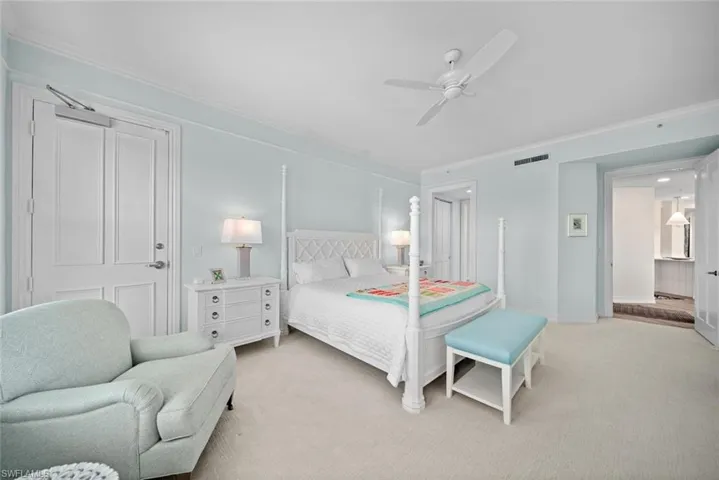 Bedroom featuring light colored carpet, ceiling fan, and crown molding