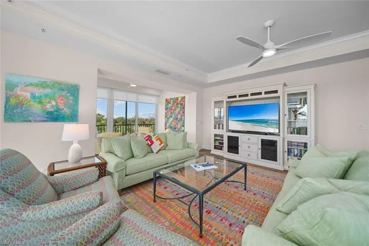 Living room with ceiling fan and crown molding