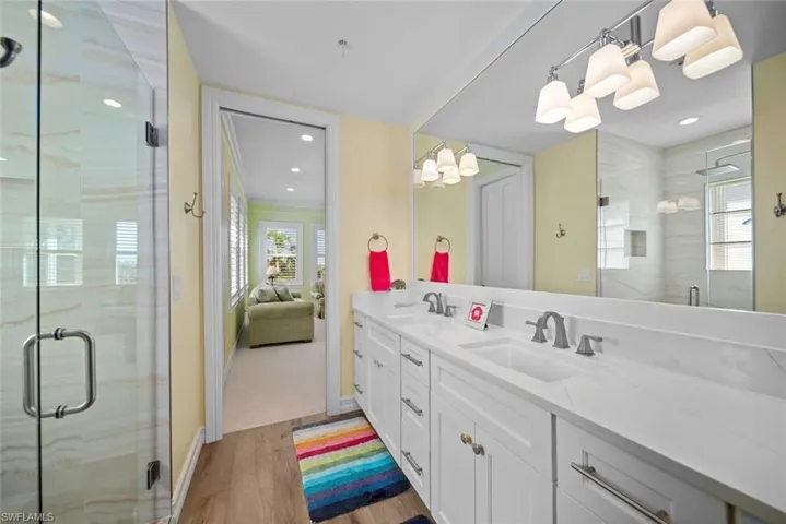 Bathroom with hardwood / wood-style flooring, vanity, and walk in shower