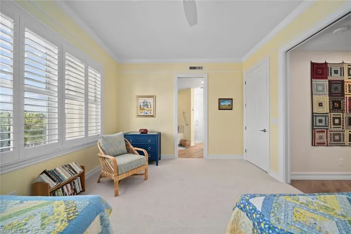 Bedroom featuring light carpet, ceiling fan, and crown molding