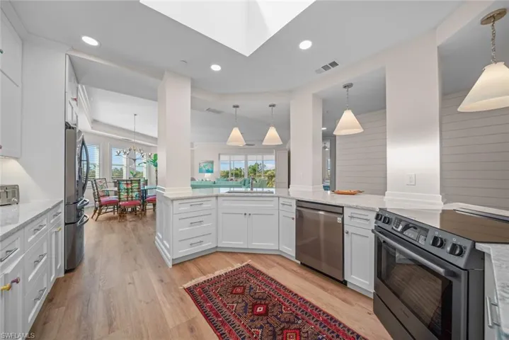 Kitchen with white cabinetry, kitchen peninsula, a healthy amount of sunlight, and stainless steel appliances