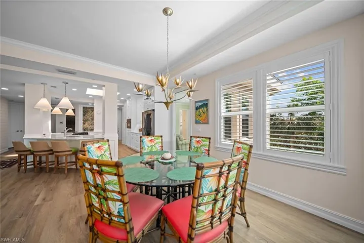 Dining area with a chandelier, light hardwood / wood-style floors, and crown molding