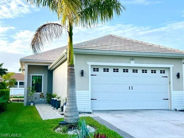 Stucco exterior with a tile roof, an integrated two-car garage, a concrete driveway, and a concrete walkway to the entry
