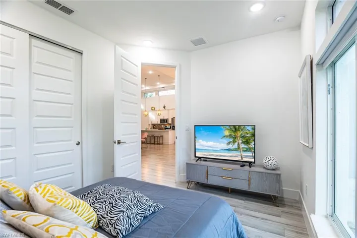 Bedroom with visible vents, a closet, and wood finished floors