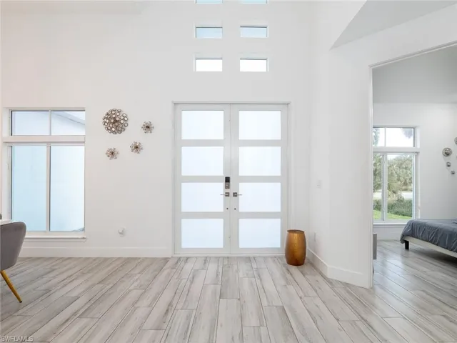 Foyer featuring french doors, baseboards, and light wood-type flooring