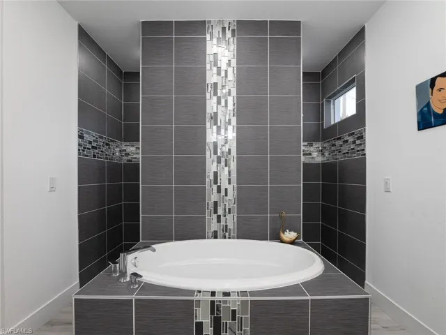 Full bath featuring a bath and baseboards