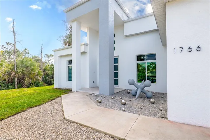 View of exterior entry with a yard and stucco siding
