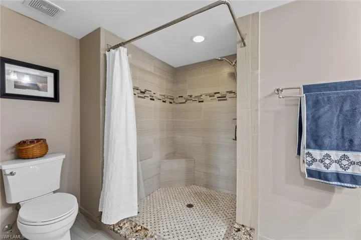 Bathroom featuring toilet and a shower with curtain