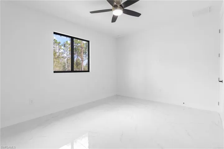 Unfurnished room with marble finish flooring and ceiling fan
