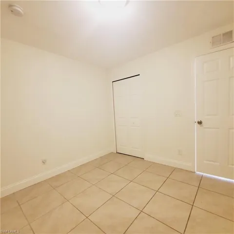 Unfurnished bedroom with light tile patterned floors and a closet