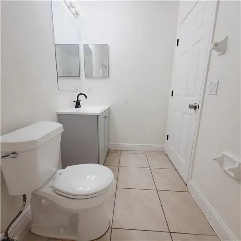 Half bath featuring light tile patterned floors and vanity