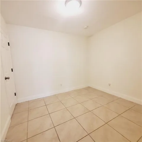 Spare room with light tile patterned flooring and baseboards