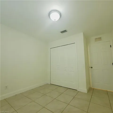 Unfurnished bedroom with light tile patterned floors and a closet