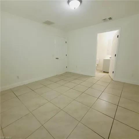 Unfurnished room featuring light tile patterned flooring and baseboards