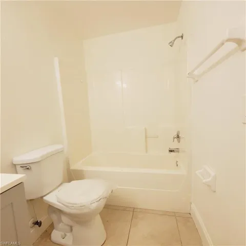 Full bathroom with tile patterned floors, vanity, and bathing tub / shower combination