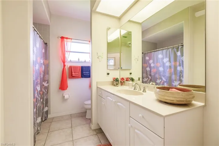 Bathroom featuring toilet, vanity, and tile patterned floors