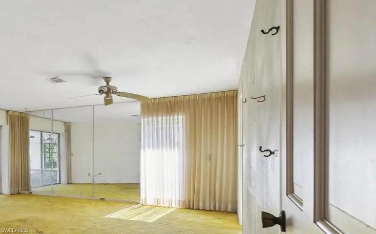 Empty room featuring ceiling fan and light carpet