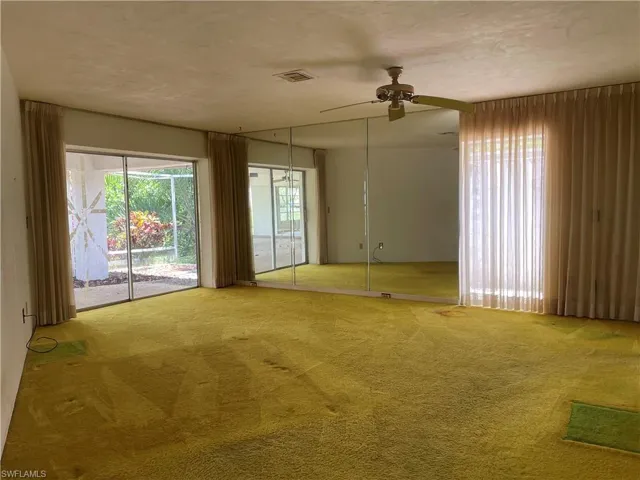 Carpeted spare room featuring ceiling fan