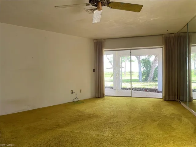 Carpeted spare room with ceiling fan