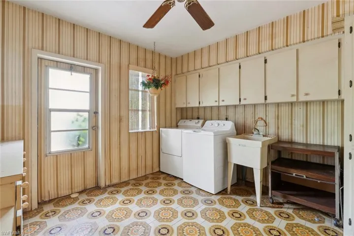 Laundry area featuring ceiling fan, washing machine and clothes dryer, cabinets, and light tile patterned flooring