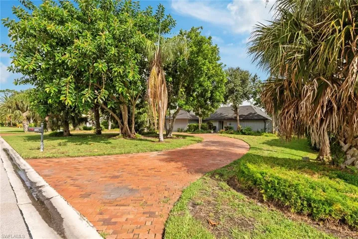 View of driveway with a yard