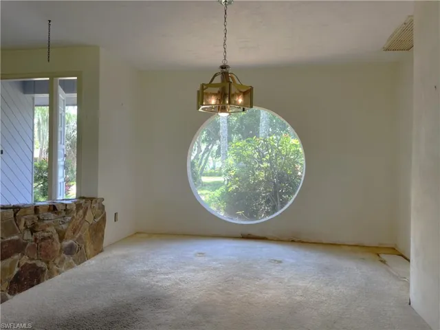 Carpeted empty room with a chandelier