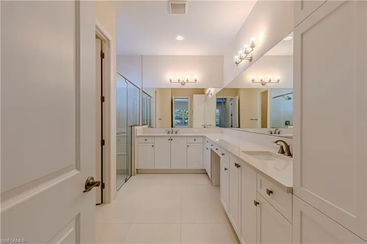 Bathroom with double vanity, a stall shower, light tile patterned flooring, and recessed lighting