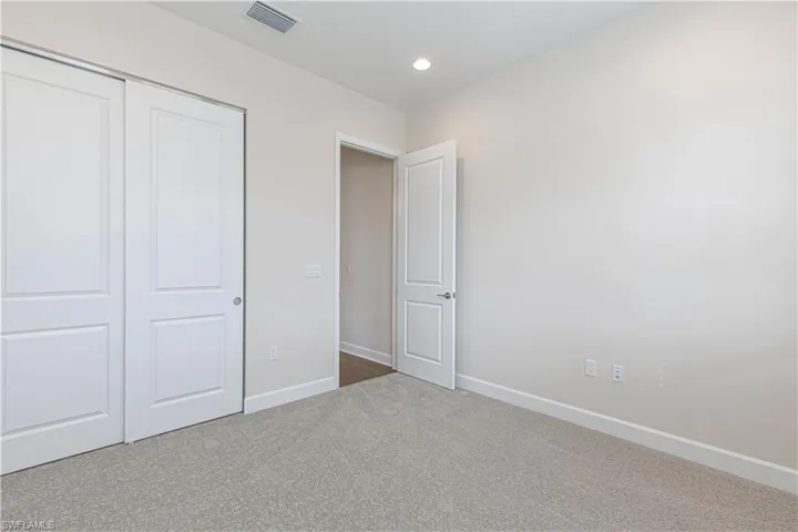 Unfurnished bedroom with carpet, a closet, and recessed lighting