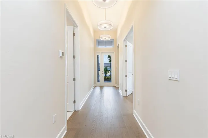 Hallway with baseboards and wood-type flooring