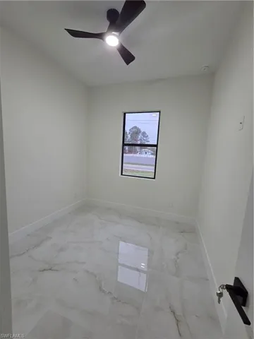 Empty room with light marble finish flooring and ceiling fan