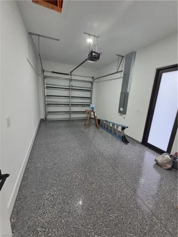 Garage featuring a garage door opener and electric panel