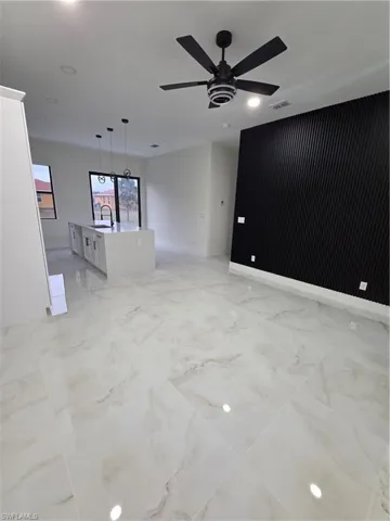 Unfurnished living room featuring recessed lighting, a ceiling fan, and light marble finish floors