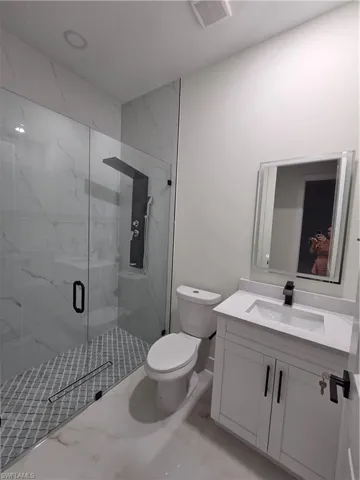 Full bathroom featuring vanity and a marble finish shower