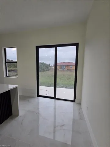 Unfurnished dining area with light marble finish flooring and baseboards