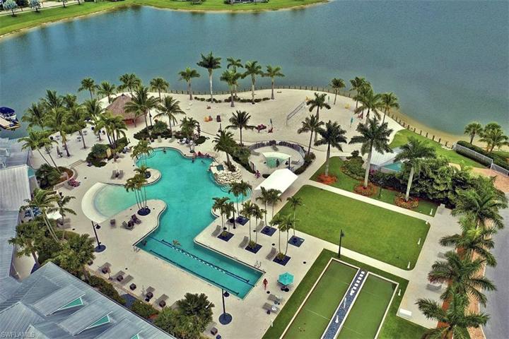 Aerial view of the lagoon-style pool with lap lanes, Sunset Beach with beach volleyball court, bocce ball courts, and picturesque Eagle Lake.