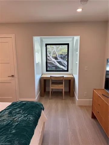 Bedroom with connected bathroom and light hardwood / wood-style flooring
