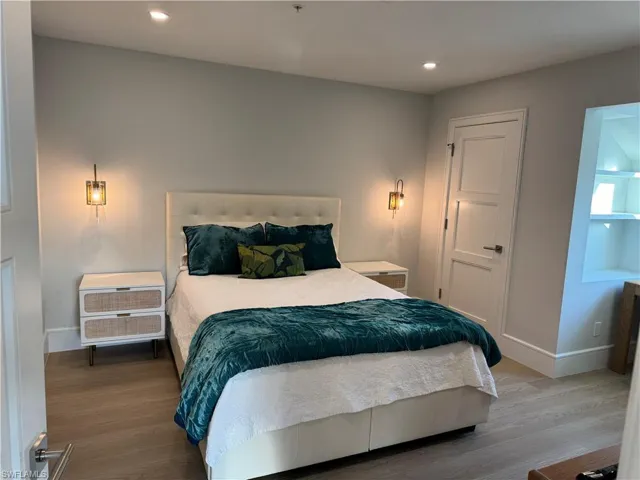 Queen Bedroom featuring wood-type flooring, walk in closet and office nook