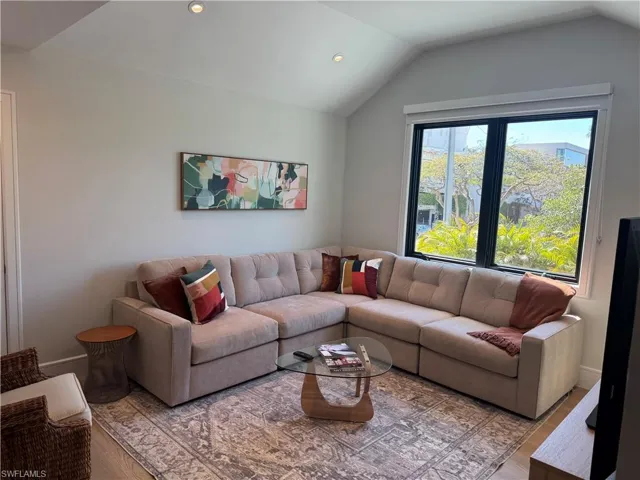 Living room featuring lofted ceiling, baseboards, wood finished floors, and recessed lighting