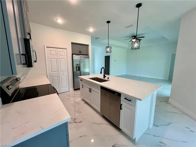 Kitchen with stainless steel appliances, light QUARTZ countertops, a center island