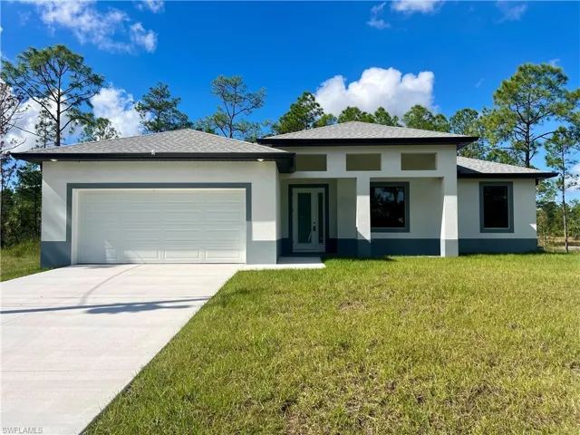 Front of house featuring a garage and a front lawn