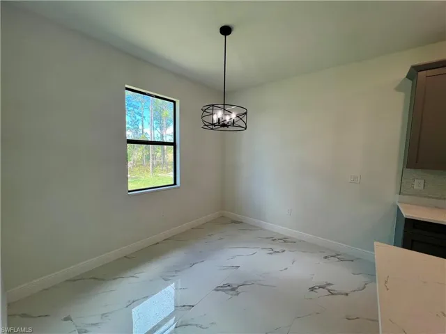 Unfurnished dining area featuring a notable chandelier