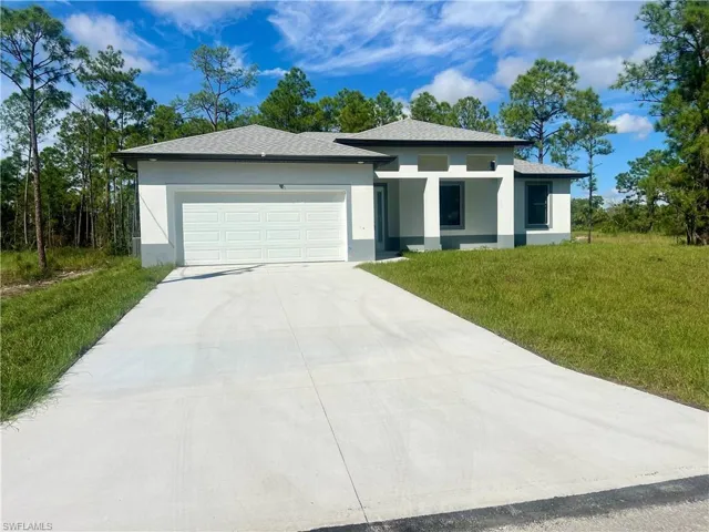 View of front of house with a front yard and an extra long driveway and garage. Plenty of parking.