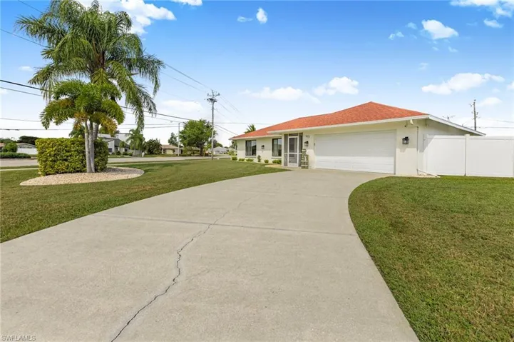 Ranch-style home featuring driveway, a garage, and stucco siding